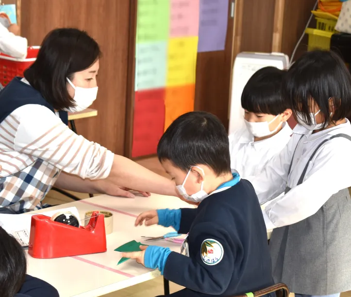 預かり保育で先生と一緒に制作活動をする園児たち
