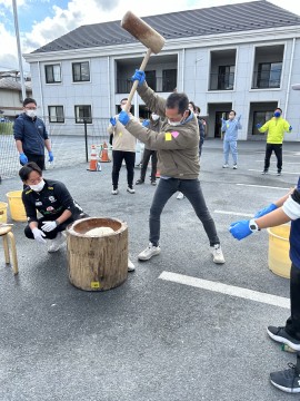 おもち月大会で、お父さんがおもちをついている様子