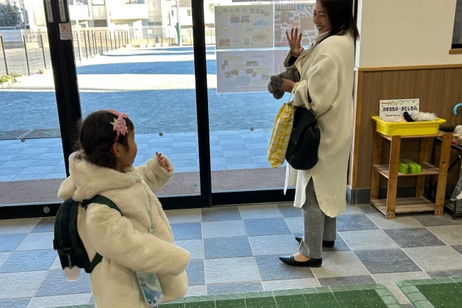 先生に迎えられて登園する園児