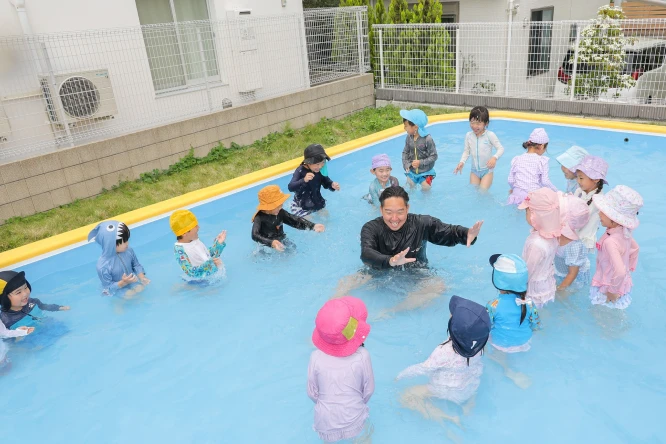 プールで水遊びを楽しむ園児たち