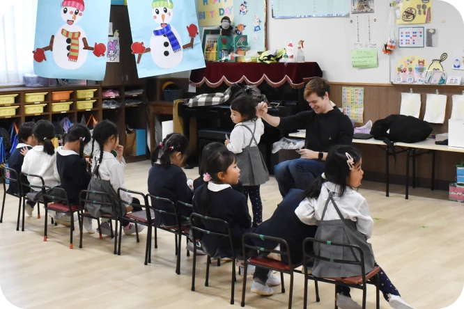 英語教室で先生の話を聞く子どもたち
