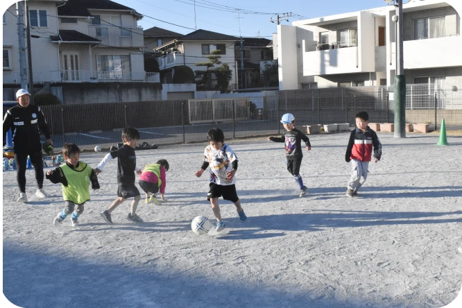 園庭でサッカーに取り組む子どもたち