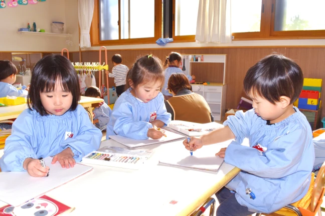 なんでもすすんでとりくみ、やりぬく子を表す、集中してお絵かきに取り組む園児たち