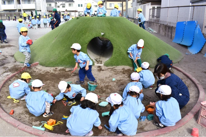 築山や砂場で遊ぶ園児たち