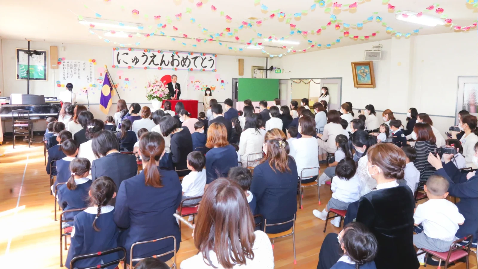 ホールで入園行事に参加する子どもたちと保護者